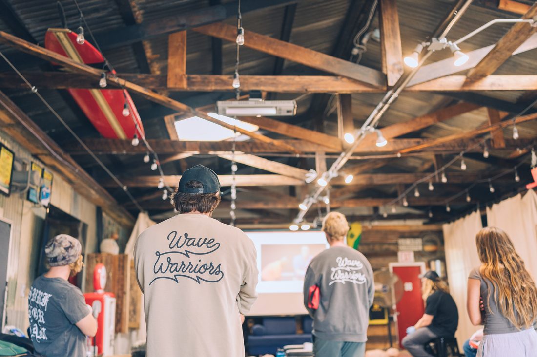 Wave Warriors gather indoors to watch a CPR and water-safety training presentation
